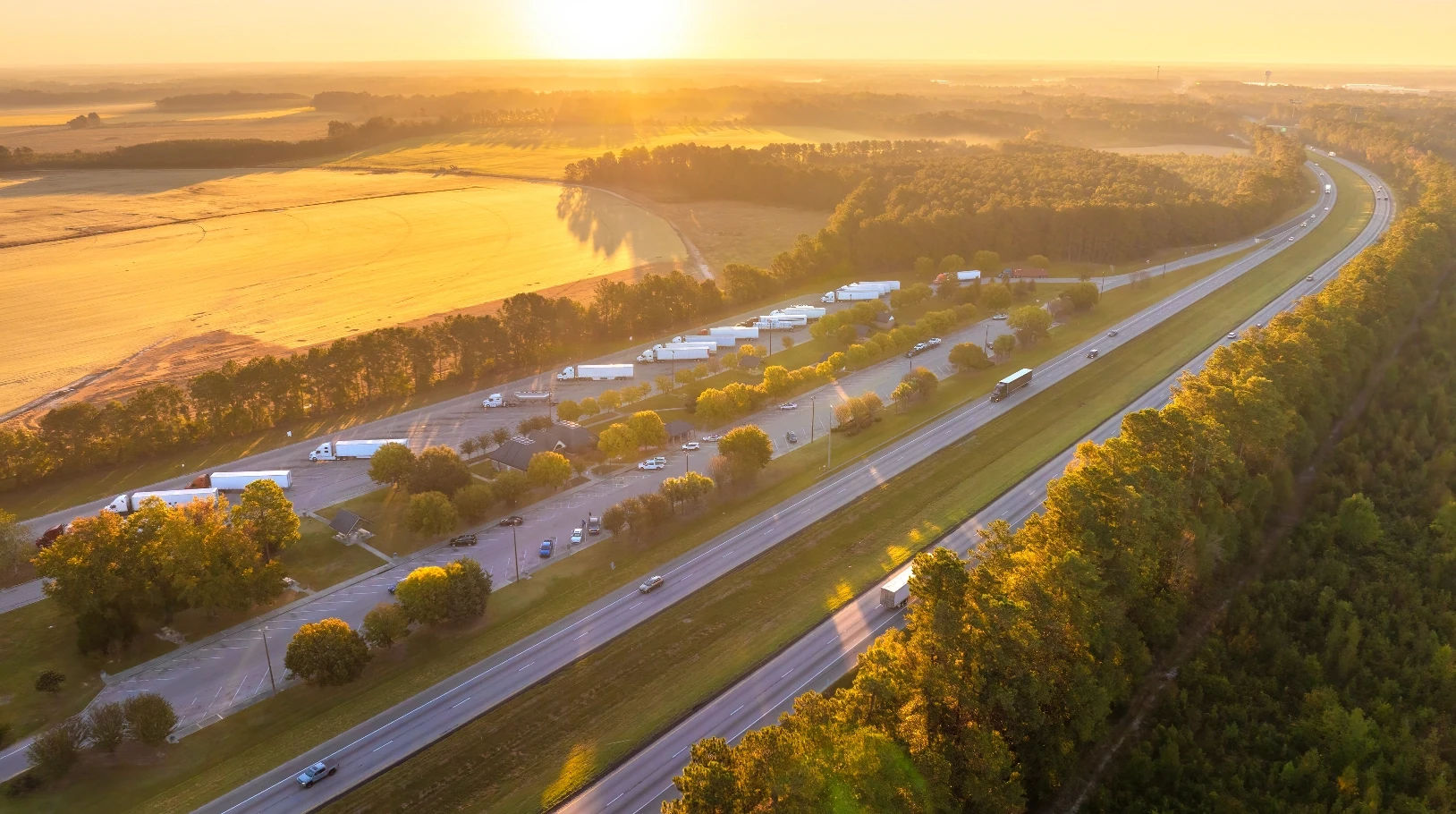Aerial view of a highway and industrial facilities at sunset