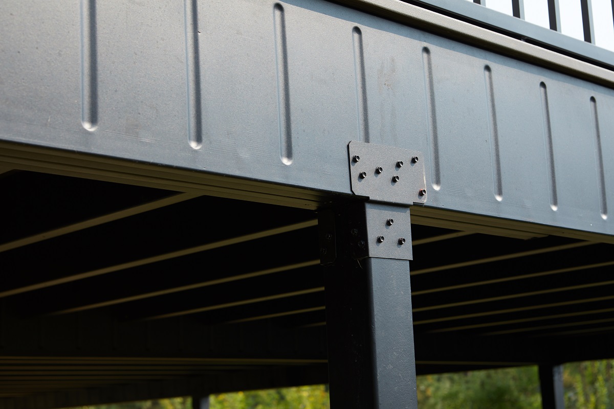 Metal railing on a deck, highlighting the steel deck framing and joists used in construction.