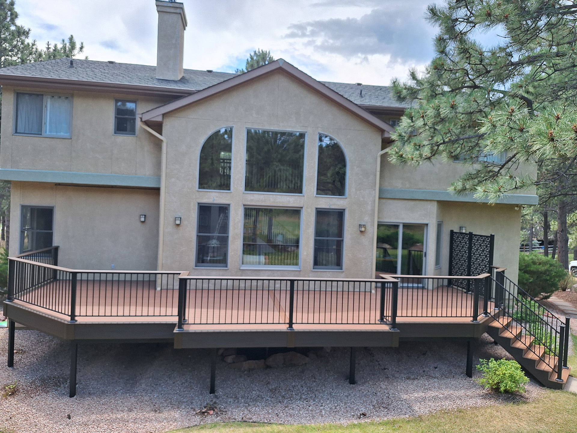 Large home featuring a fire-resistant deck and stairs, designed for safety and compliance with fire codes.