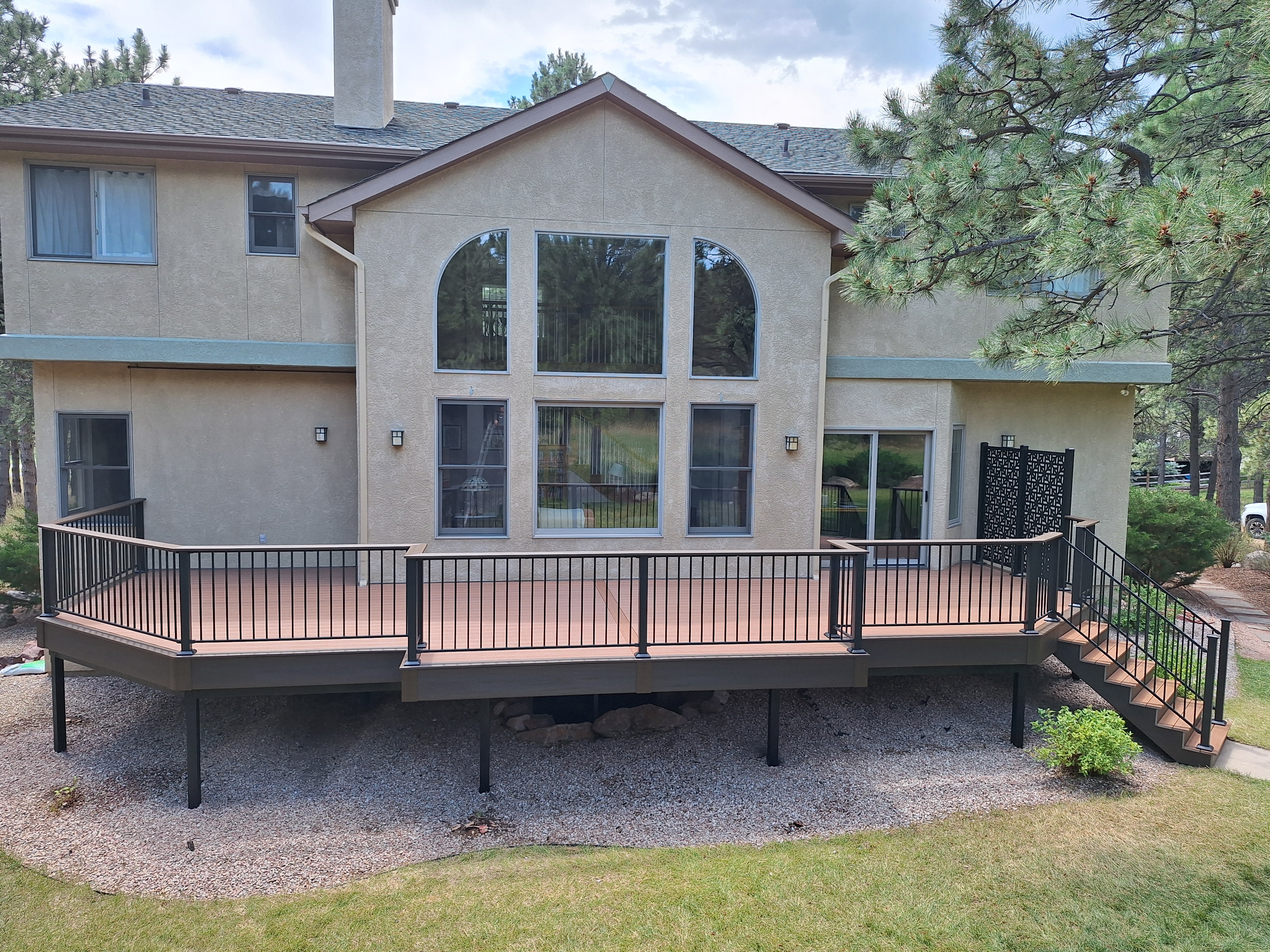Modern steel deck with durable black railing and privacy screen on elevated residential home.