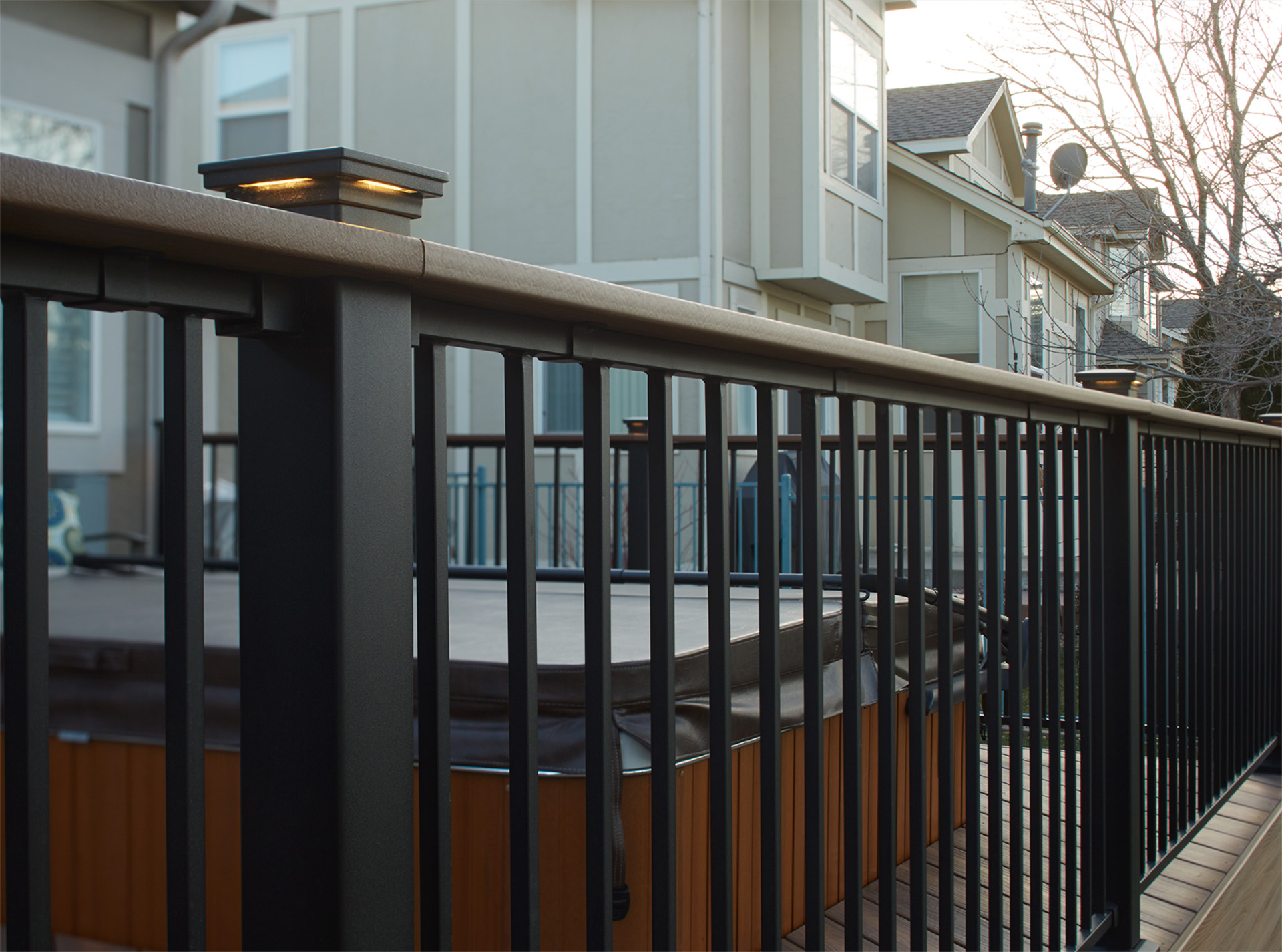 Deck railing with post lighting, casting subtle light on a patio. 