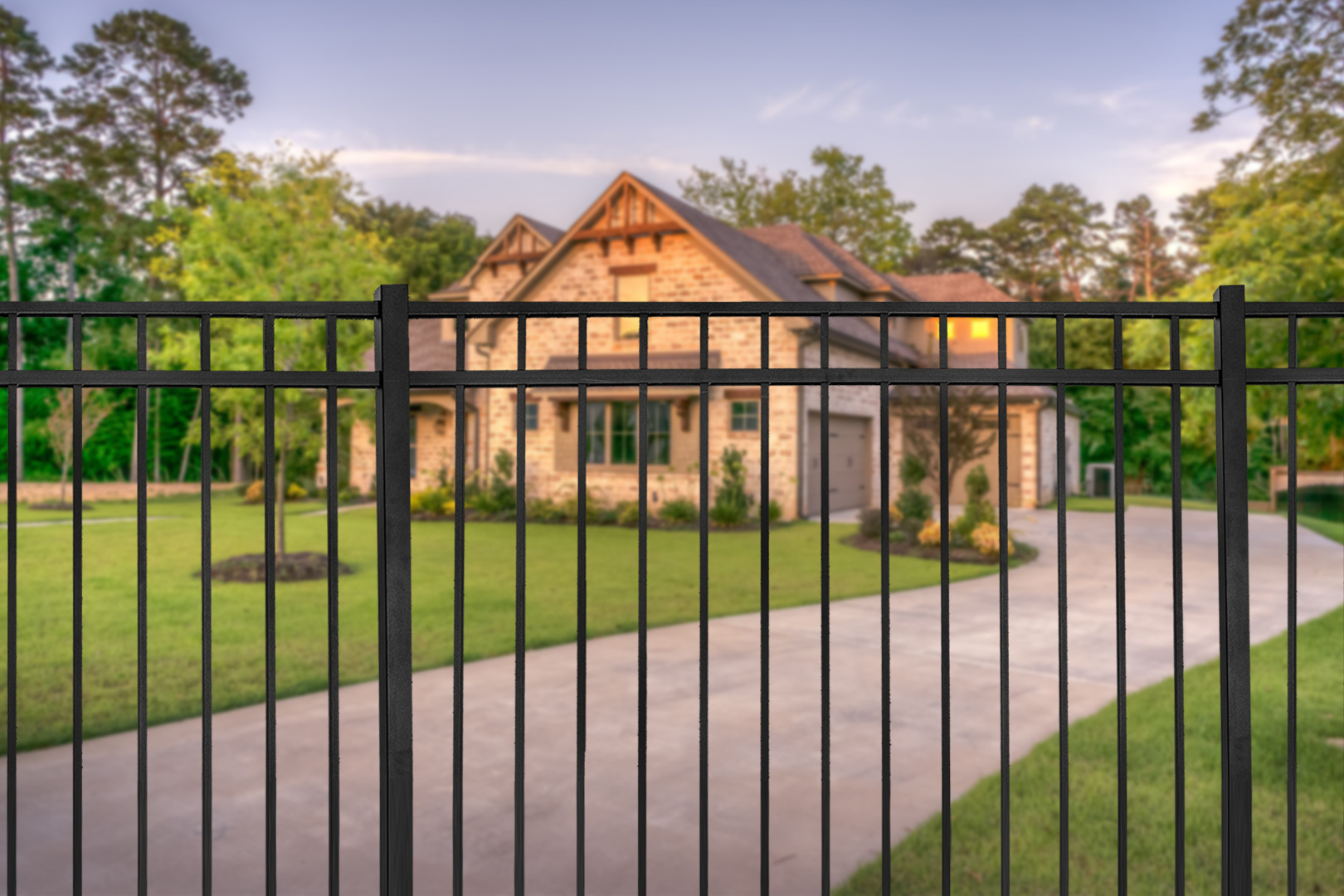 Aluminum fence bordering a residential driveway and front yard.