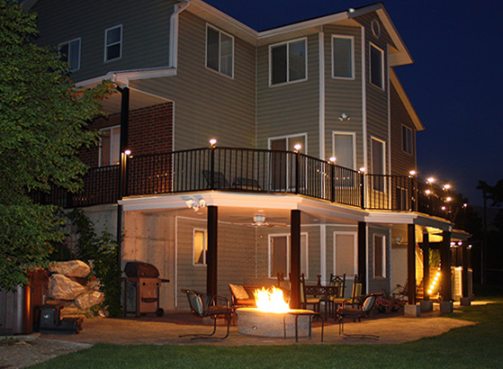 Spacious outdoor deck at night lit by post cap lights. 