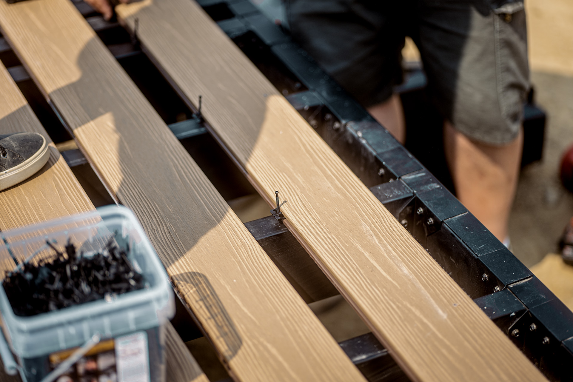 A man is working on building a fire-resistant deck frame to ensure safety and durability
