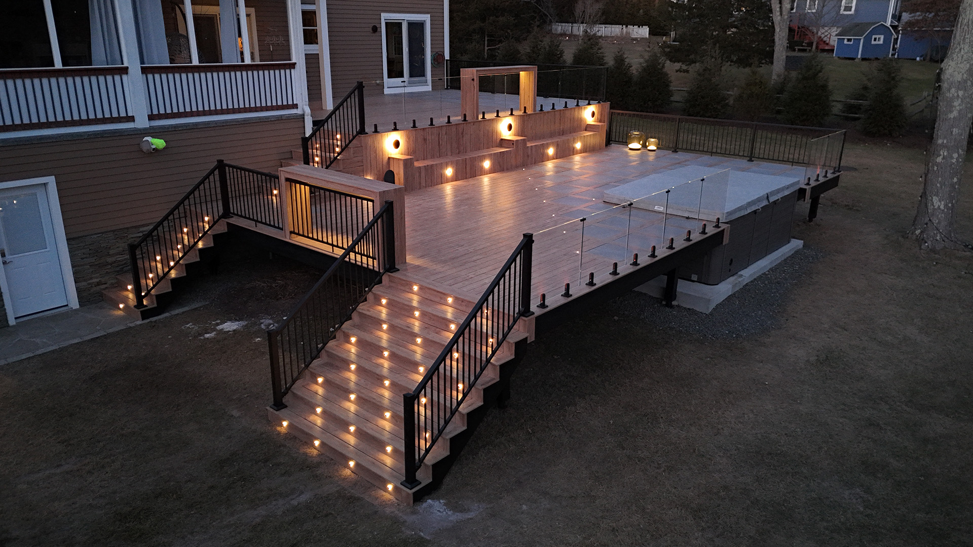 A well-lit deck with stairs leading to a house, showcasing durable deck framing and inviting outdoor space.