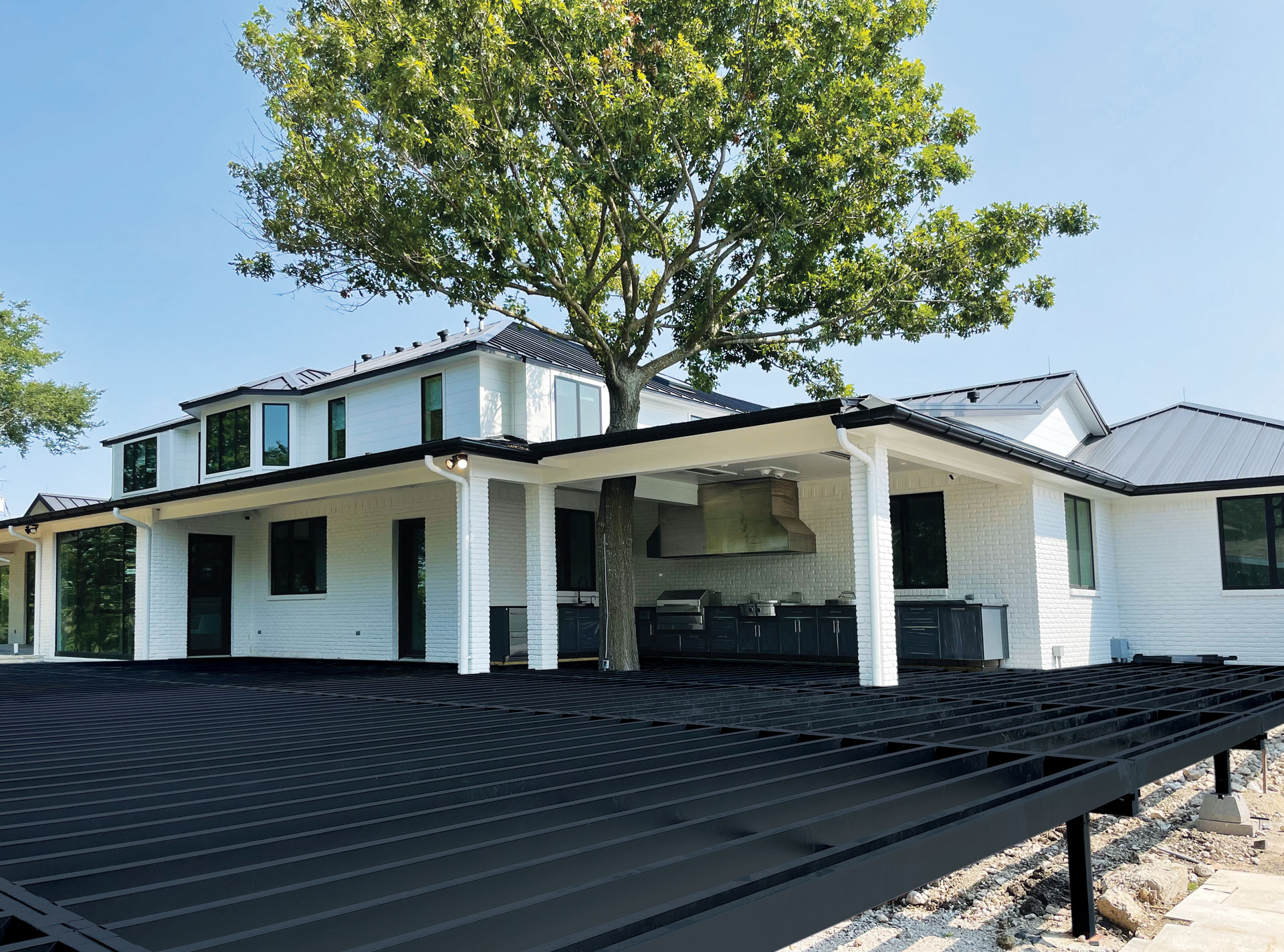 Wide view of a steel-framed deck surrounding a modern home.