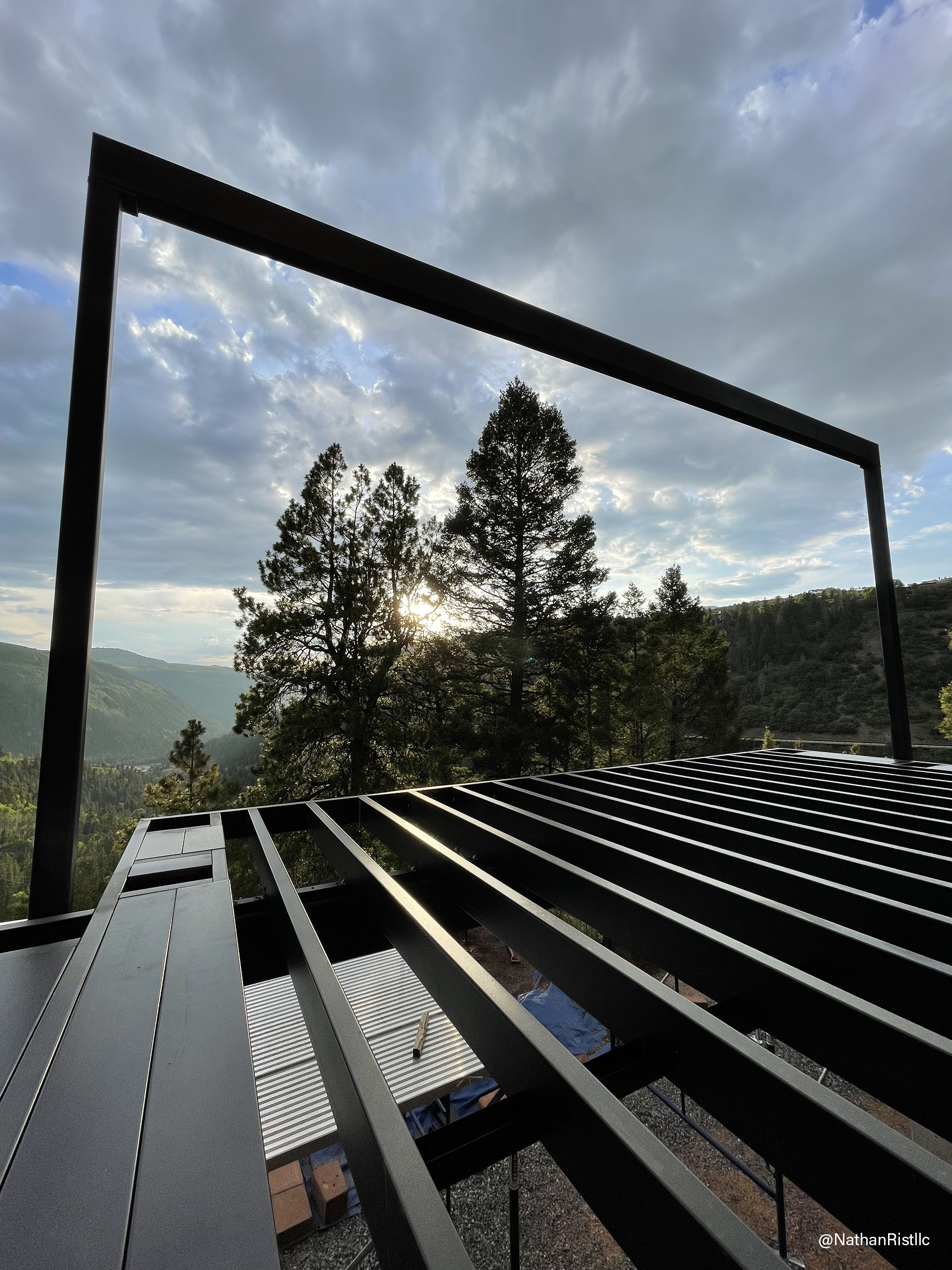 View from the top of a steel deck framing structure, showcasing the durable deck and surrounding landscape below. URL: