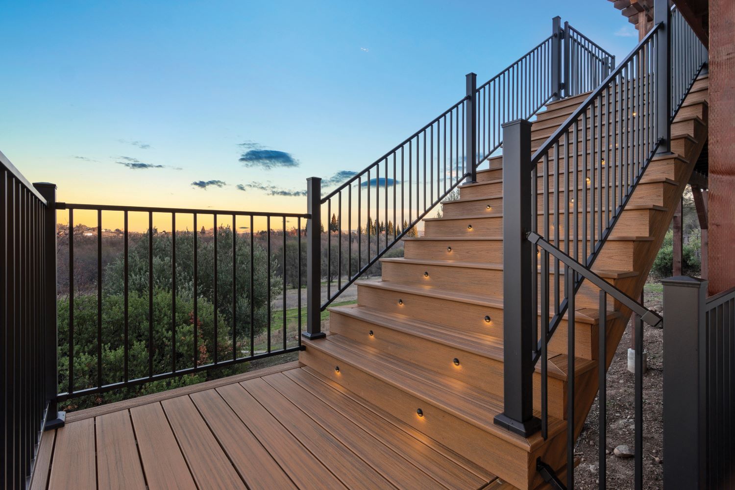 Steel deck stairs with Fortress railing and lighting at sunset with scenic view.