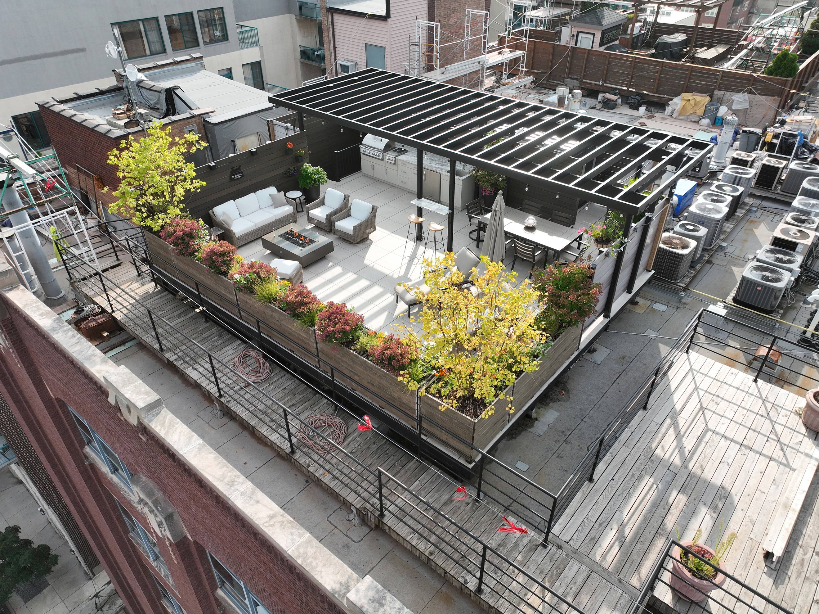 Aerial perspective of a rooftop garden with a weatherproof patio and fireproof deck, highlighting vibrant greenery.