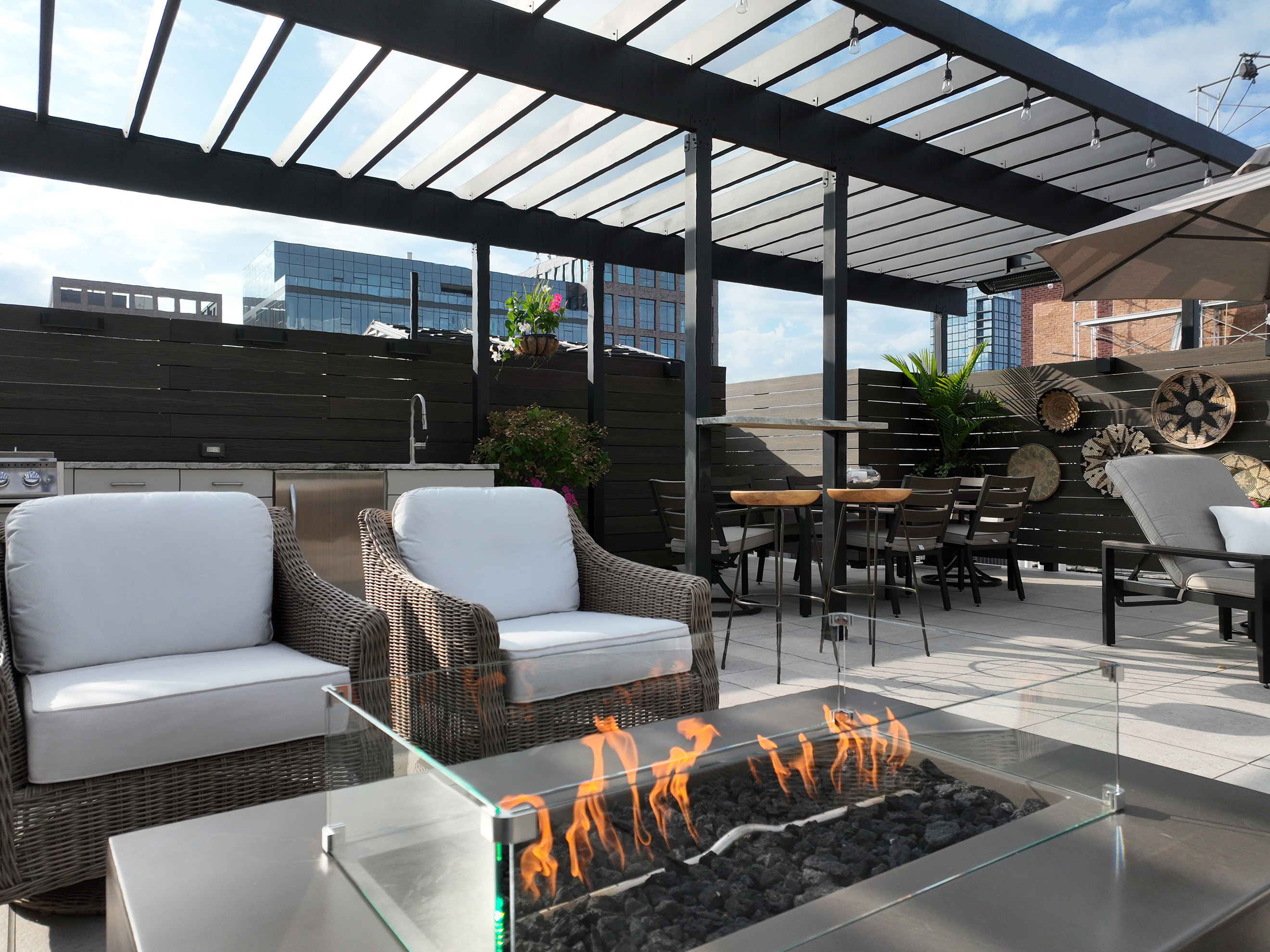 Cozy rooftop patio with a fire pit and chairs, set on a fireproof and weatherproof deck.